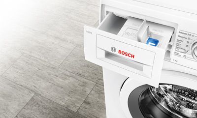 Miele Dampfgarer mit Edelstahl-Innenraum, drei Bleche mit Kartoffeln, Lachs und grünem Spargel im Garvorgang.